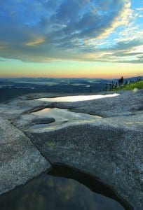 Sunrise clouds reflected in rain pools on Ampersand Mountain.