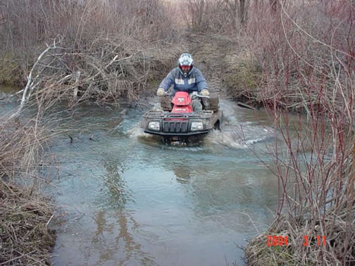 An ATV crosses an Adirondack stream. (Photo courtesy of Adirondack Council.)