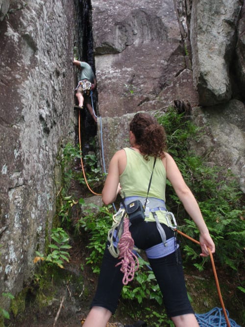 Jecinda belays Jecinda Hughes belays Josh Wilson as he begins the ascent of the chimney on Hurricane Crag. Photo by Phil Brown.
