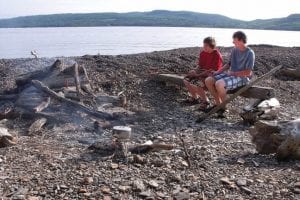 Aspiring gourmets Peter Curtis and Nicholas Mann roast hot dogs over a campfire.