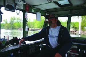 Ferry owner Michael Matot handles the throttle while cables take care of steering.