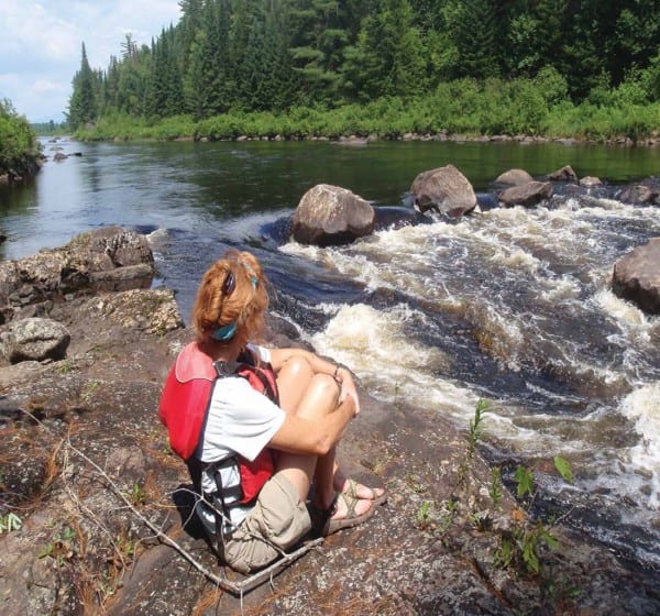 Lynda McIntyre takes in the view upriver from a rock ledge at the foot of Blackwell Stillwater. Photo by Phil Brown