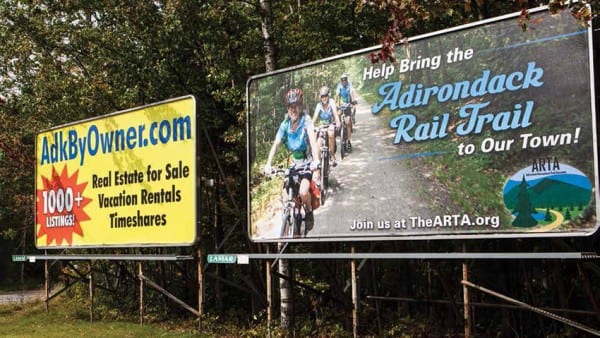 A billboard in Tupper Lake urges residents to support the trail option. Photo by Nancie Battaglia