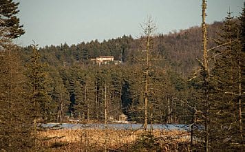 A house sticks out on a forested ridge overlooking Jones Pond.    PHOTO BY BARRY LOBDELL