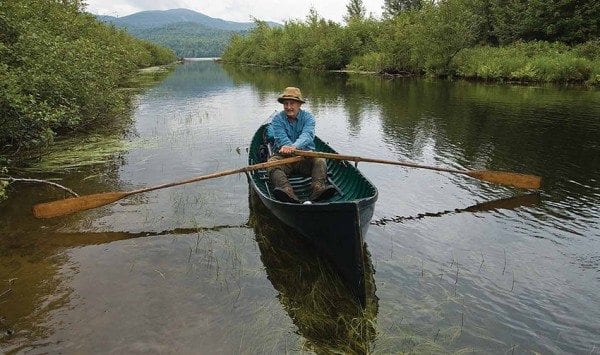 Bill Frenette rows a guideboat on a canal between the Raquette River and Big Simon Pond. Photo by Mark Bowie