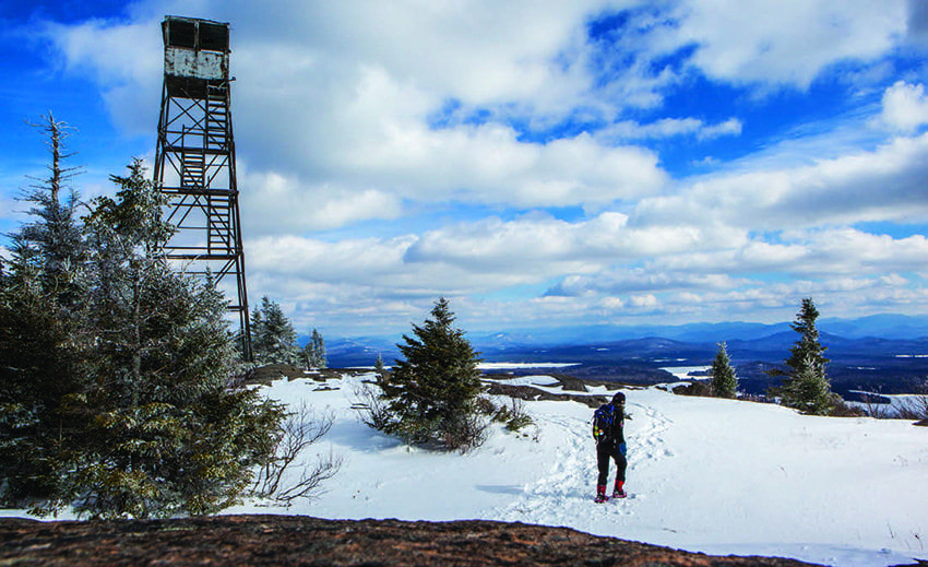 A solitary snowshoer reaches the 2,874-foot summit of St. Regis Mountain. Photo by Nancie Battaglia