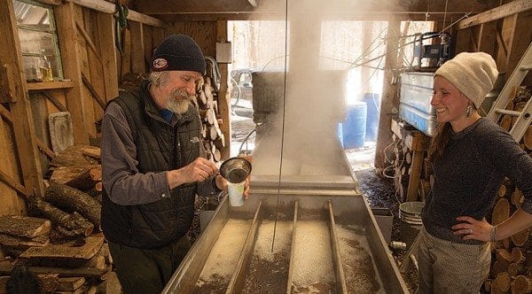 Addison Bickford pours a sample of maple syrup, while his daughter, Celeste, looks on. Photo by Mike Lynch