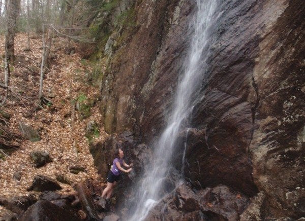 After an hour of hiking and running, Carol cools off in the mist of falling water. Photo by Phil Brown