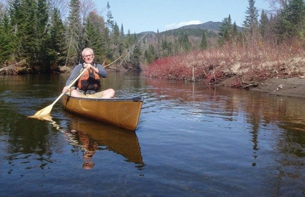 Brian Mann paddles up the Opalescent River, with Allen Mountain looming in the background. Photo by Phil Brown