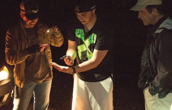 Paul Smith’s College students study a spotted salamander during its spring migration this past April, as Professor Curt Stager looks on. Photo by Mike Lynch