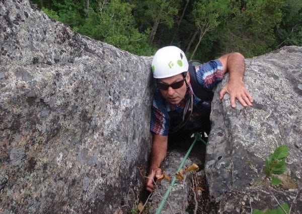 Tim Peartree squeezes through a chimney on Rooster Comb’s Old Route. Photo by Phil Brown