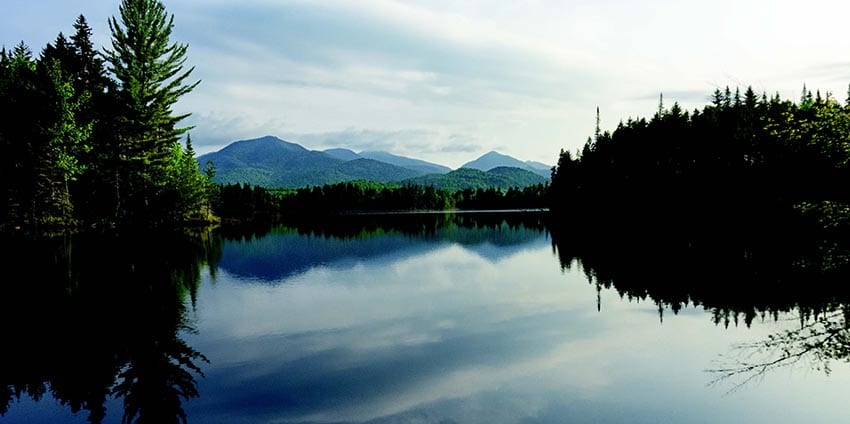 On a still morning, First Pond offers a gorgeous view of the High Peaks. PHOTO BY PHIL BROWN