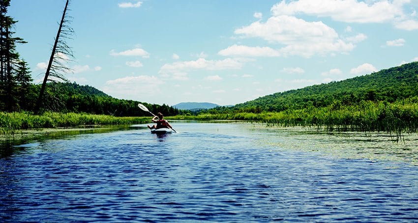 A kayaker journeys up Fishing Brook, with Kempshall Mountain looming on the horizon. PHOTO BY LISA GODFREY