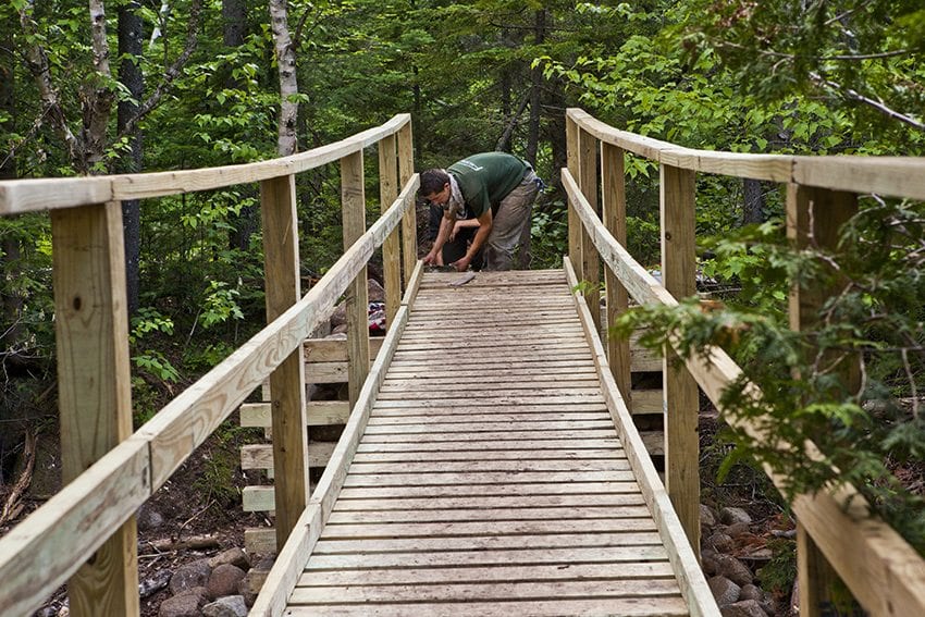 A worker puts the finishing touches on a bridge over Marcy Brook in 2012. PHOTO BY NANCIE BATTAGLIA 