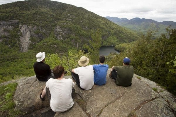Hikers take in a view of Chapel Pond and nearby cliffs during a hike up Giant Mountain.
