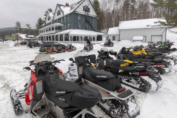 Snowmobiles are lined up outside of the Adirondack Hotel in Long Lake. Photo by Mike Lynch