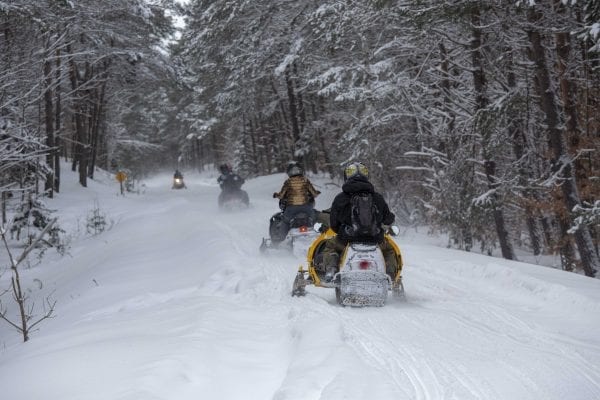 Snowmobilers ride the abandoned railroad line through Lake Clear. Photo by Mike Lynch