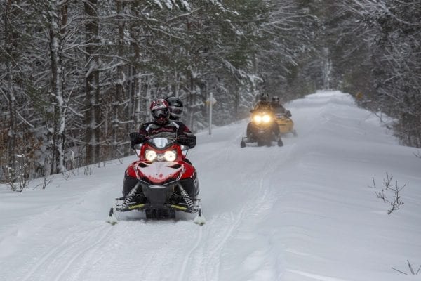 Snowmobilers ride the abandoned railroad line through Lake Clear. Photo by Mike Lynch