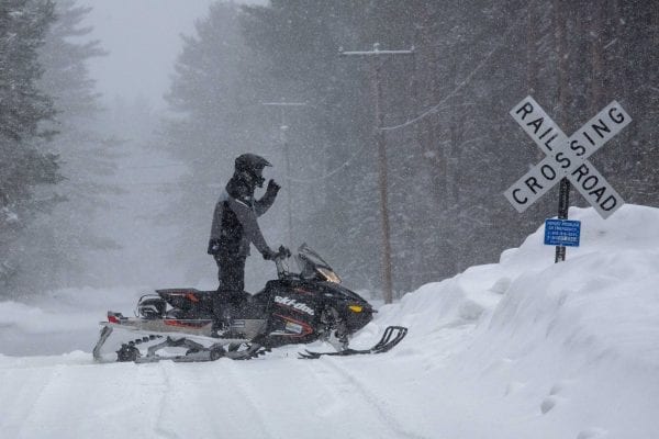 A snowmobiler crosses a road in Lake Clear in Franklin County. Photo by Mike Lynch
