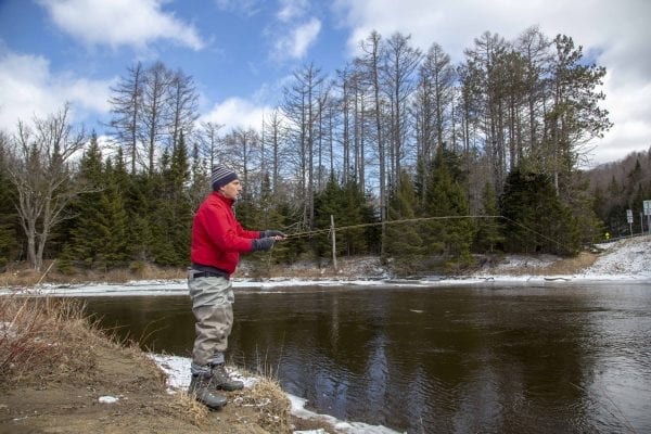A fly fisherman braves the cold on the West Branch of the Ausable River on April 1 2019, the opening day of the trout fishing season. Photo by Mike Lynch
