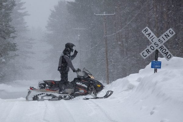 A snowmobiler crosses the road in Lake Clear.  Photo by Mike Lynch