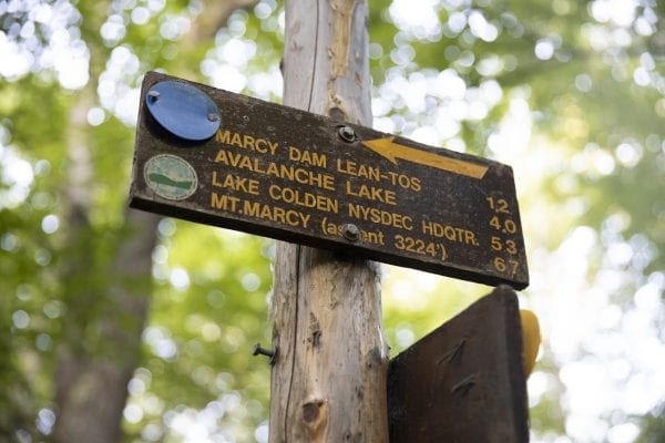 A trail sign to Marcy Dam and other popular destinations in the High Peaks. Photo by Mike Lynch