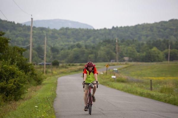 A Cycle Adirondacks participant rides through farmlands in the Champlain Valley. Photo by Mike Lynch