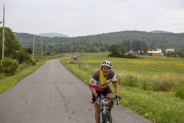 A Cycle Adirondacks participant rides through farmlands in the Champlain Valley. Photo by Mike Lynch