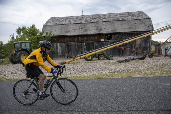 A Cycle Adirondacks participant rides through farmlands in the Champlain Valley. Photo by Mike Lynch