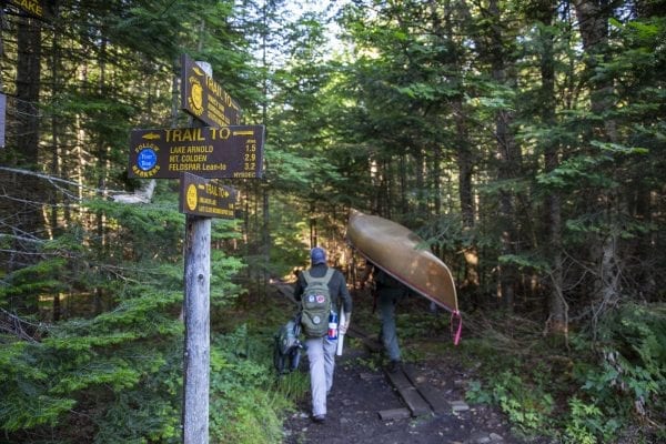 A "hiker" portages a Hornbeck canoe into the High Peaks Wilderness to explore Avalanche Lake and Lake Colden in late July. Photo by Mike Lynch