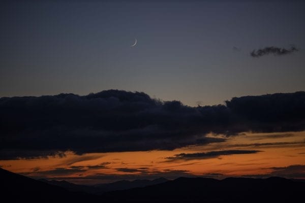 A crescent moon in the sky above the sunset and High Peaks was visible from Hurricane Mountain fire tower. Photo by Mike Lynch