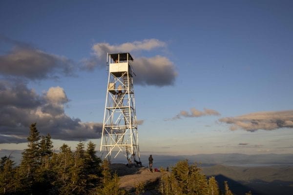 The Hurricane Mountain fire tower lit up by the sun shortly before sunset. Photo by Mike Lynch