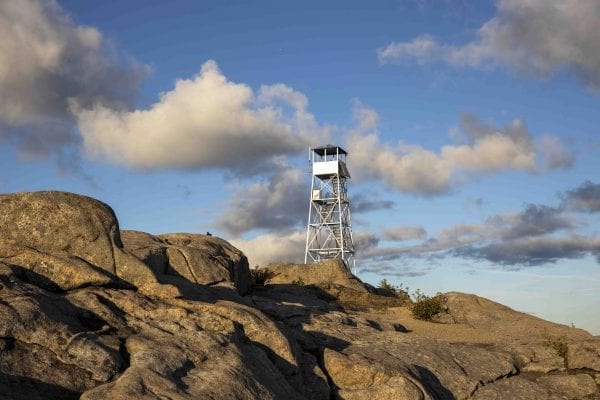 The Hurricane Mountain fire tower lit up by the sun shortly before sunset. The tower is 100 this year. Photo by Mike Lynch