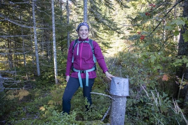 Adirondack Explorer Publisher Tracy Ormsbee stands next to a "trail marker" in the Five Ponds Wilderness. Photo by Mike Lynch