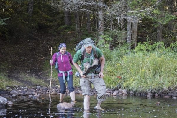Sam Eddy and Tracy Ormsbee cross the Middle Branch of the Oswegatchie River in the Five Ponds Wilderness. Photo by Mike Lynch
