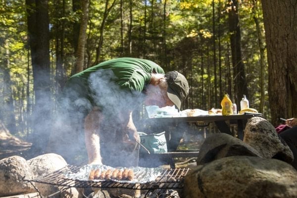 Sam Eddy cooks up some hot dogs at the Sand Lake lean-to. Photo by Mike Lynch