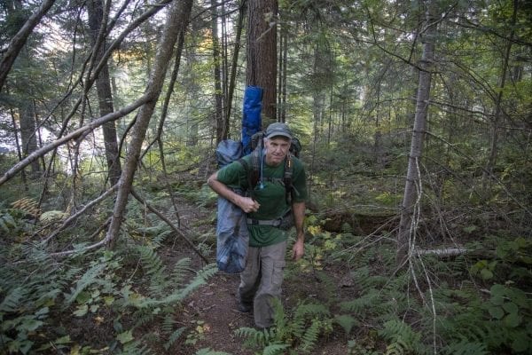 Sam Eddy carries out some garbage he found in the Five Ponds Wilderness. Photo by Mike Lynch