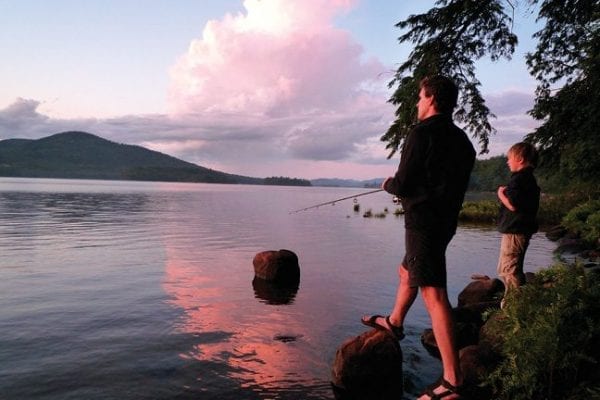 After an afternoon rainstorm, Eric Siy and his son, Leo, fish along the eastern shore of Long Lake.