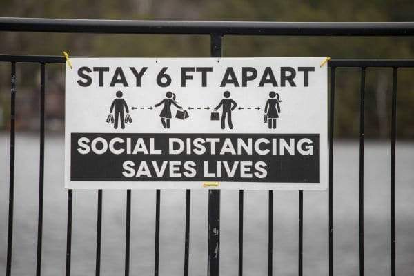 A sign in downtown Lake Placid encourages people to comply with social distancing guidelines. Photo by Mike Lynch