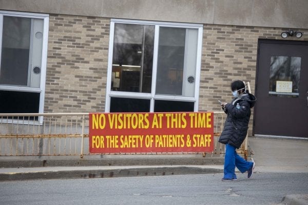 A woman walks out of the  Adirondack Medical Center in Saranac Lake, which had its services drastically reduced during the spring due to the pandemic. Photo by Mike Lynch