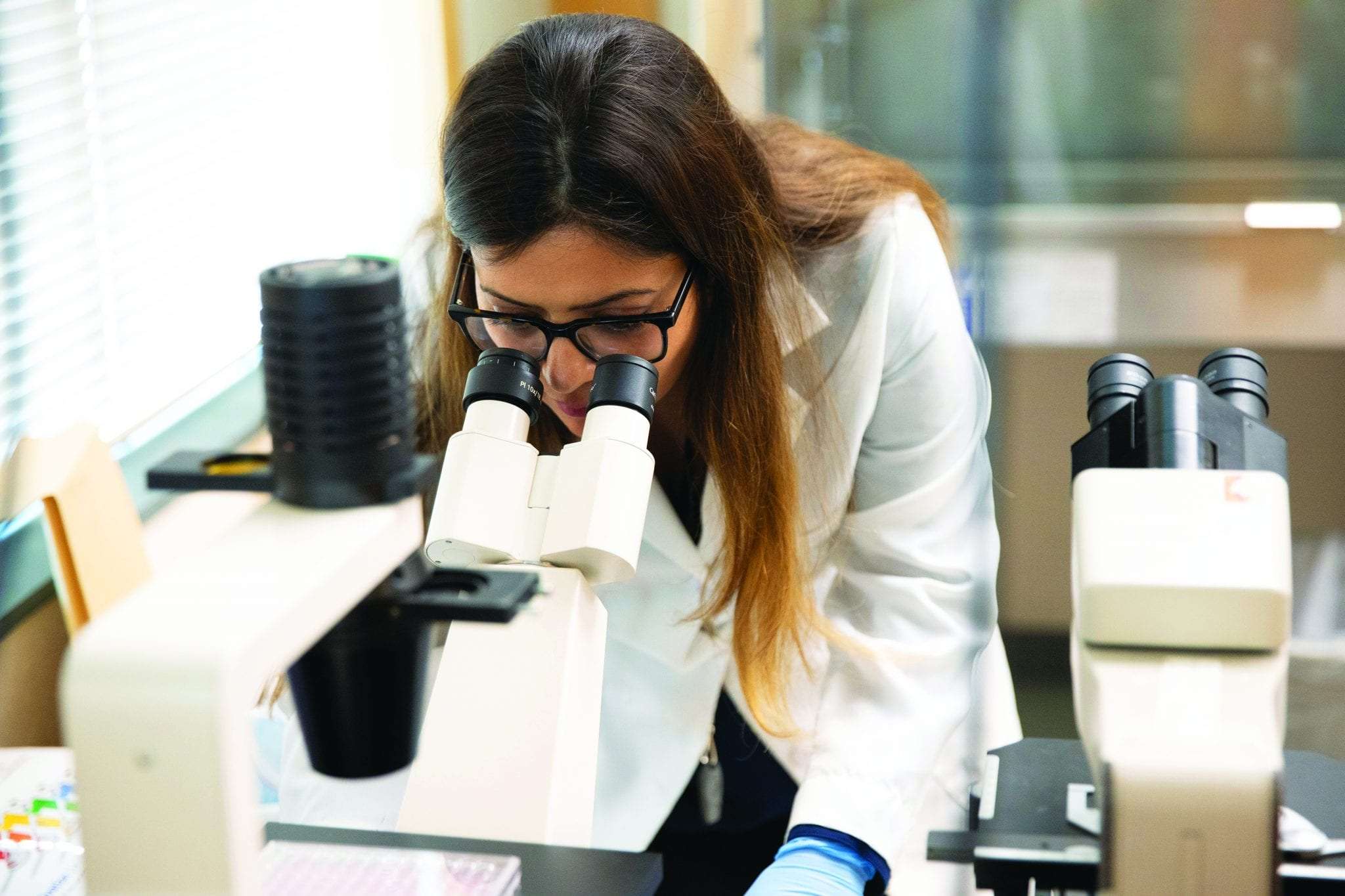 woman looking into a microscope