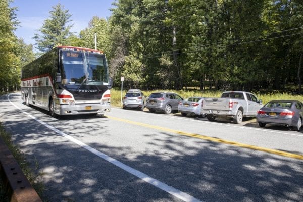 A bus drives down Route 73 by the Giant Mountain trailhead. Photo by Mike Lynch