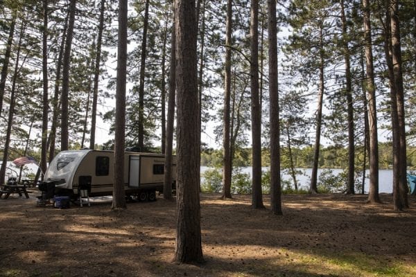 A trailer among the pines at the Fish Creek Pond Campground. Photo by Mike Lynch