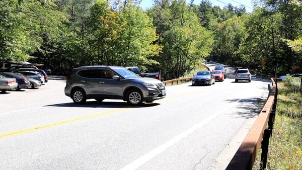 The vehicles coming downhill in this photo are paused to allow a car to leave the parking lot during this moment of confusion.