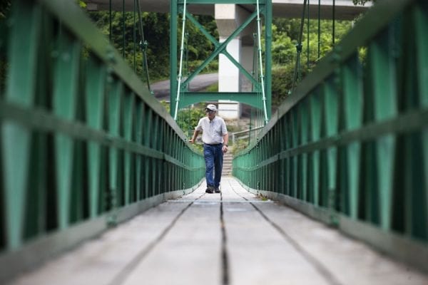 Don Lee, 75, walks the Saranac River Pedestrian Bridge in Plattsburgh.  Photo by Benjamin Chambers