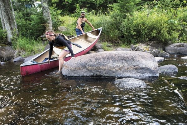 Cat Boland, 33, and Cooper Lambla, 32, both from North Carolina, prepare to canoe on the Saranac River near Frankin Falls Road. Photo by Benjamin Chambers