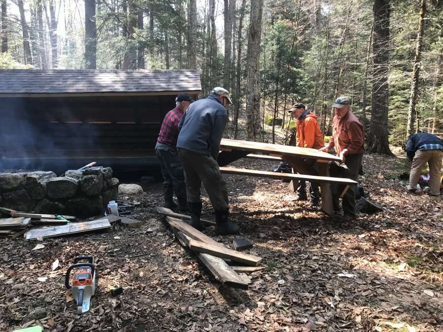 Workers build a picnic table at the Kiwassa Lake lean-to.