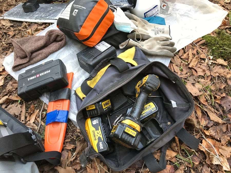 Tools and a surgical mask rest on the ground at the Kiwassa Lake lean-to site.