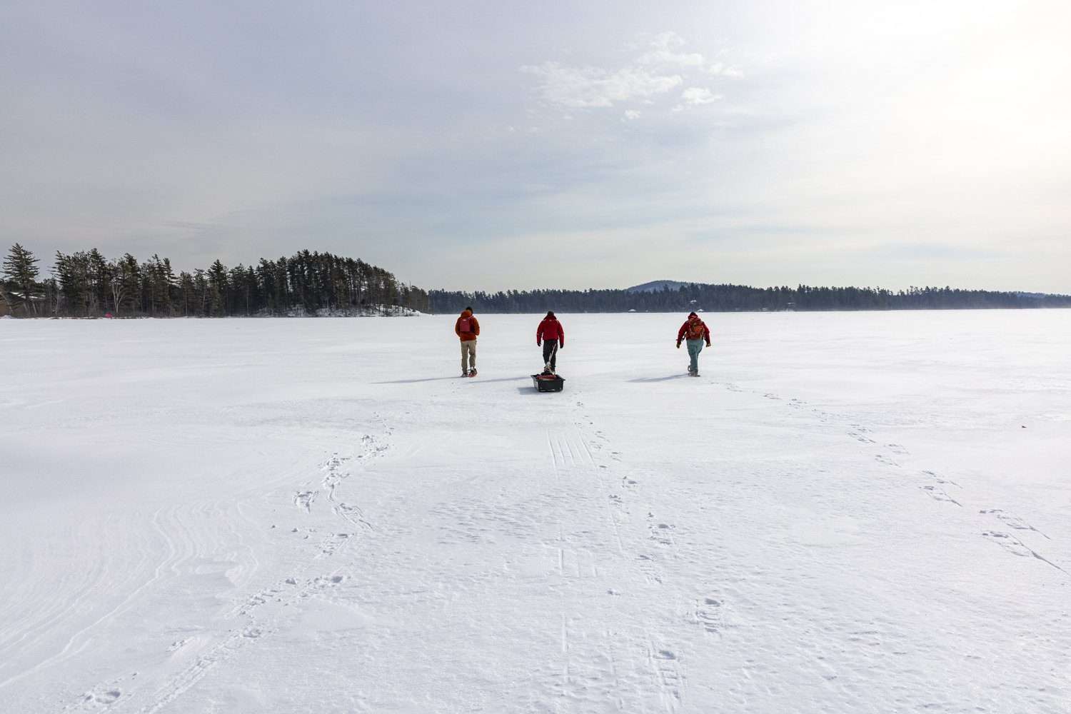 Scientists make their way across Lower St. Regis Lake to get ice data.