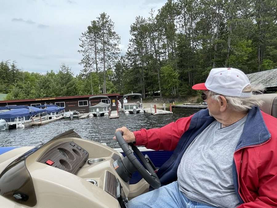 man in boat near upper saranac lake marina